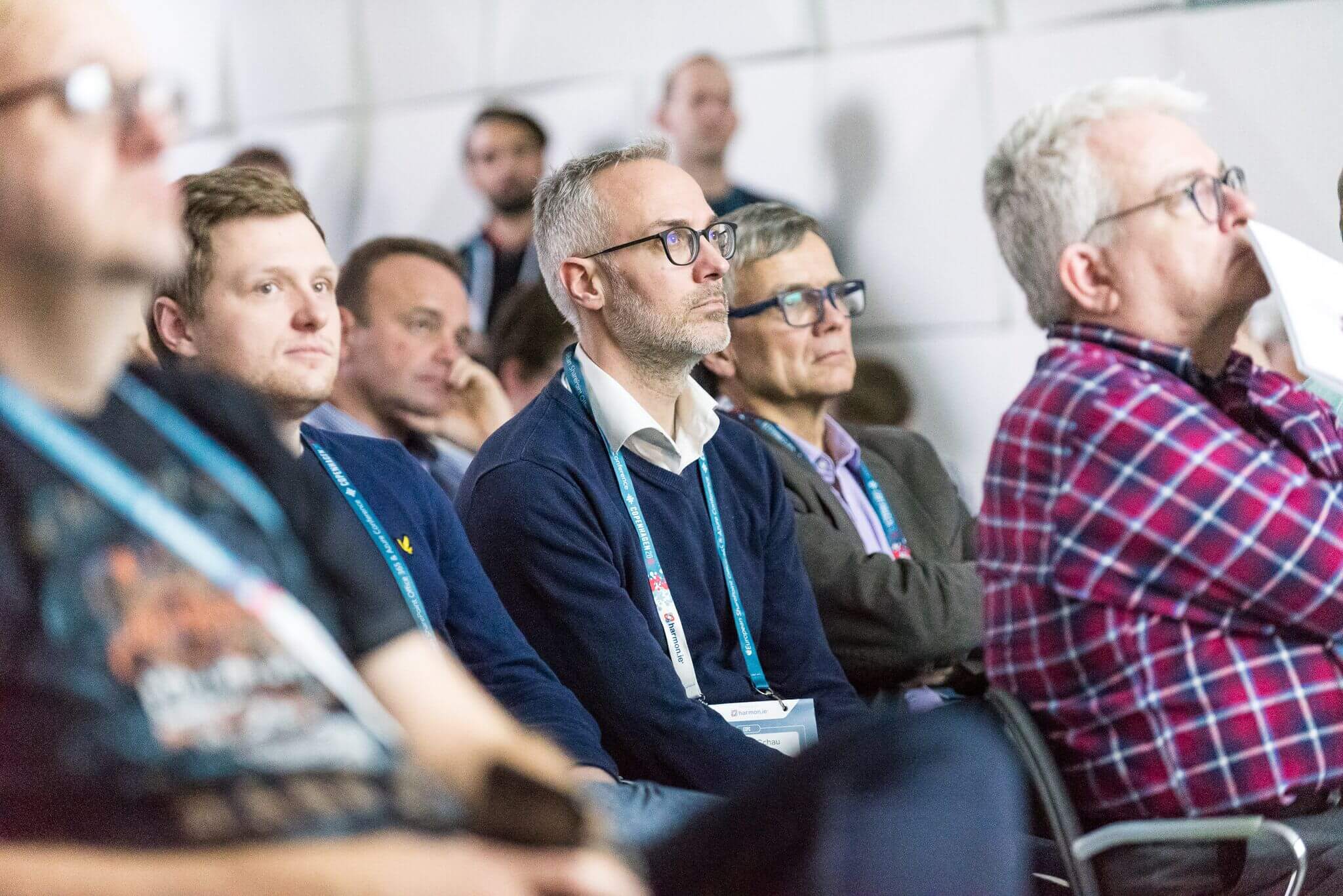 man listening closely in. a busy room of a conference learning session