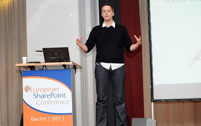 conference speaker standing up beside a lectern during a conference session