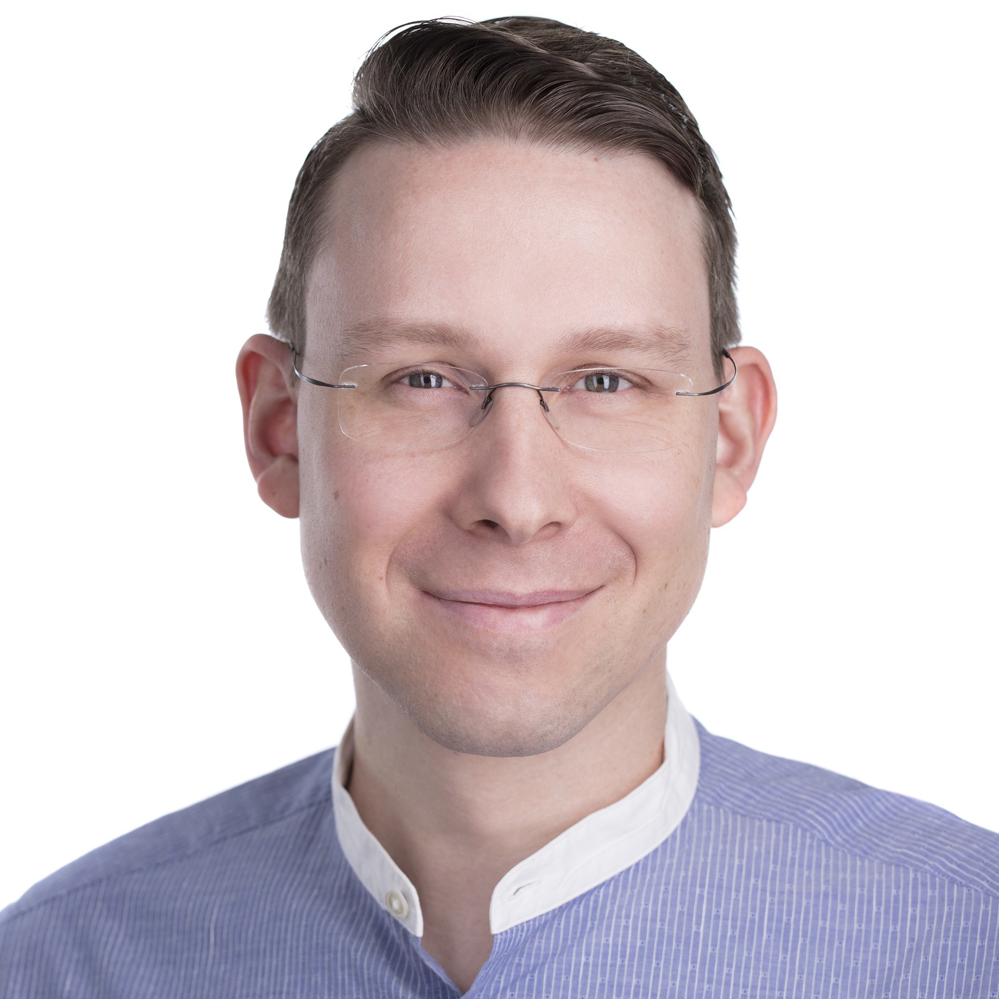 A person is shown from the shoulders upward wearing a light‑colored collared shirt with a contrasting darker neckline. The background is plain and brightly lit.