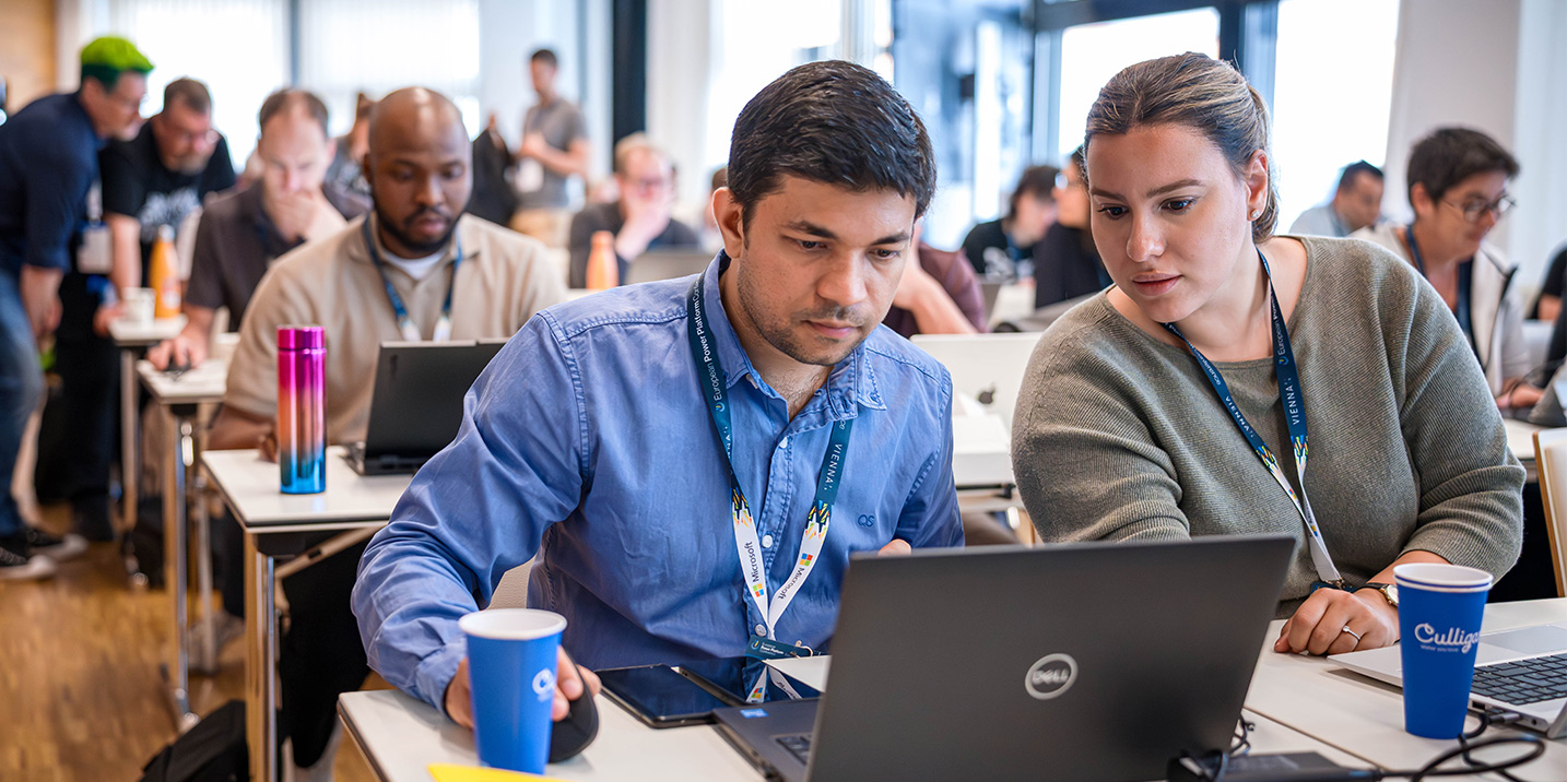 Two EPPC attendees looking at their laptop during a session