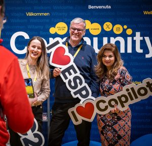 People hold up signs saying 'I Love ESPC' and 'I Love Copilot' in the COmmunity Lounge area of ESPC Stockholm25