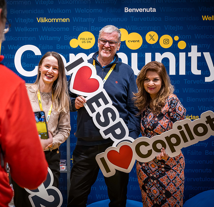 People hold up signs saying 'I Love ESPC' and 'I Love Copilot' in the COmmunity Lounge area of ESPC Stockholm25