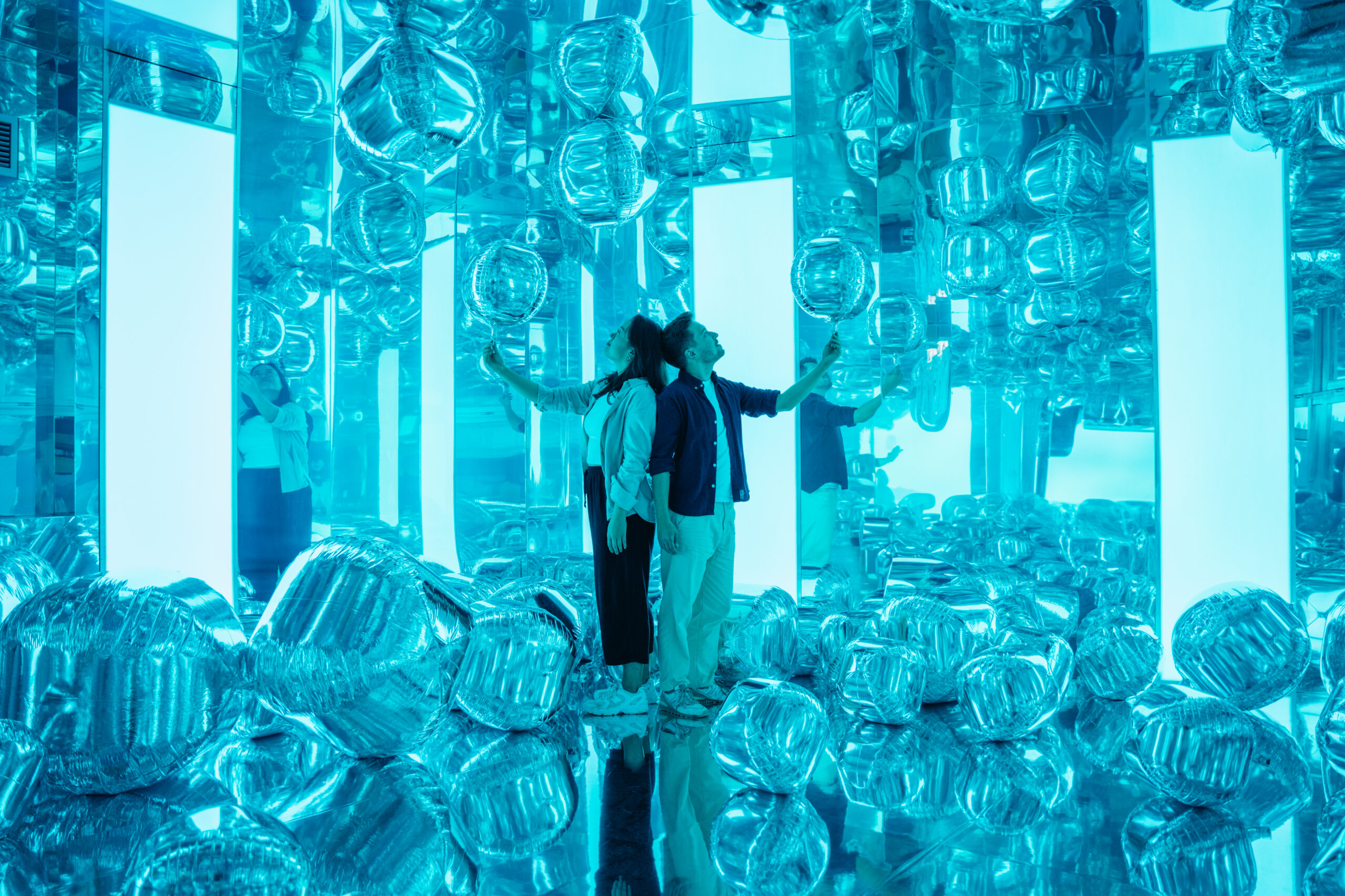 Two people surrounded by balloons in an interactive room in IKONO Copenhagen