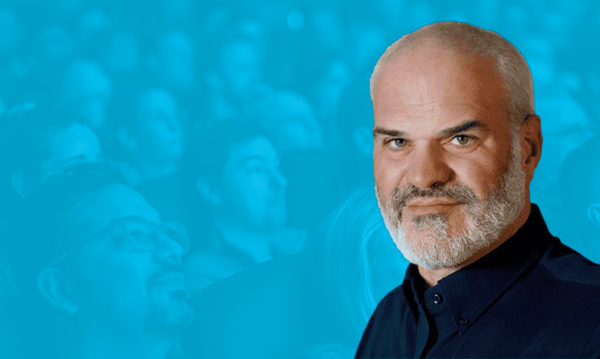 ESPC sponsor Ragnar Heil smiles for the camera over a background of a sitting audience