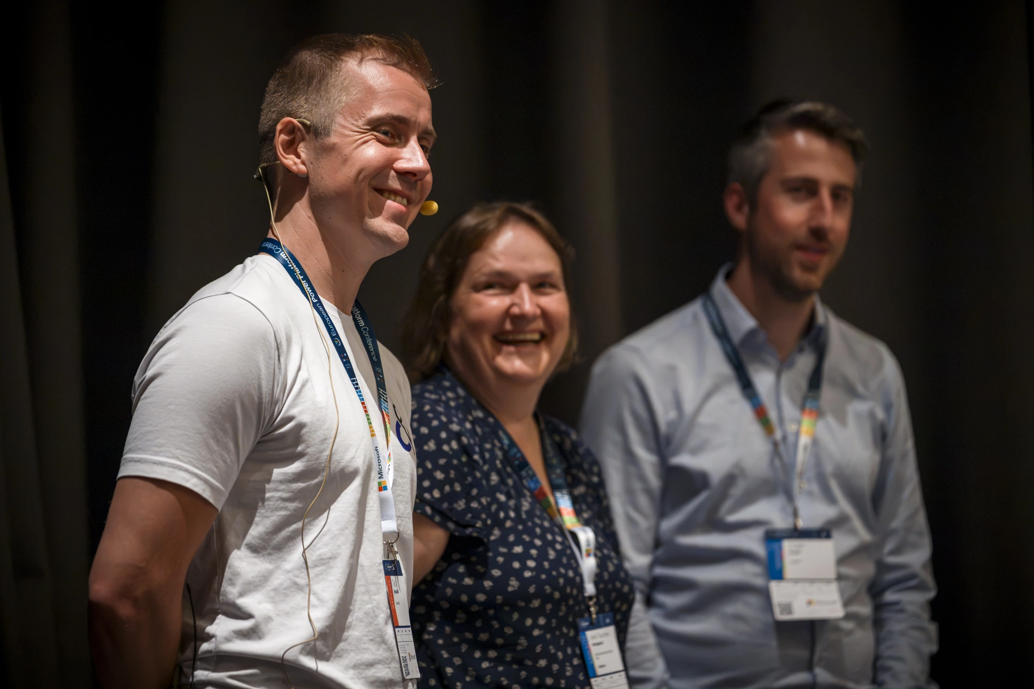 Group of speakers smiling and laughing on stage